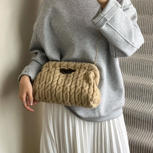 Handmade knitted crossbody bag with chunky cable knit texture and golden chain strap