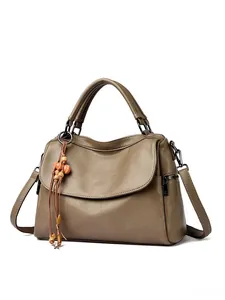 Close-up of brown litchi pattern leather texture and retro wooden bead tassel detail