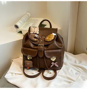 Close-up of vintage brown PU leather backpack with plush pins and buckle details
