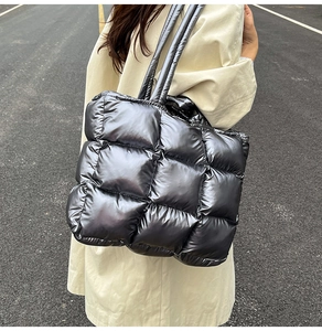 Close-up of metallic silver quilted puffer tote bag with thick padded shoulder straps