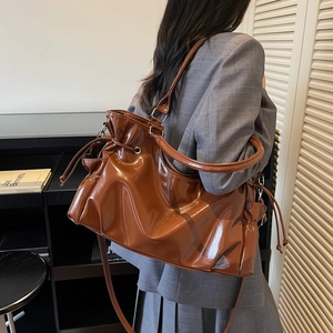 Brown gloss PU leather tote bag with drawstring closure and adjustable shoulder strap