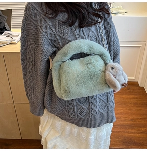 Détail du sac à main en fausse fourrure vert menthe avec pendentif lapin et chaîne