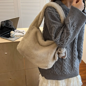 Minimalist beige plush shoulder bag with cute rabbit charm in a cozy lifestyle setting
