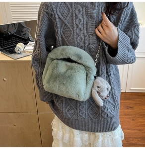 Detail of mint green plush crossbody bag with metal chain and cute rabbit charm decoration