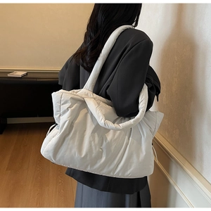 Détail du sac à bandoulière matelassé blanc montrant sa texture et sa large sangle