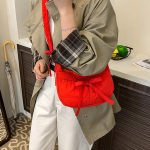 Bright red nylon crossbody bag with drawstring bow and minimalist casual slouchy design