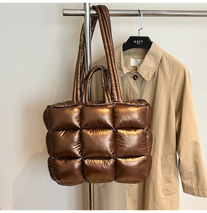 Close-up of metallic quilted puffer tote bag in bronze coffee hanging on a hanger