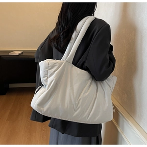 Détail du sac à bandoulière matelassé blanc montrant sa grande capacité et sa texture douce