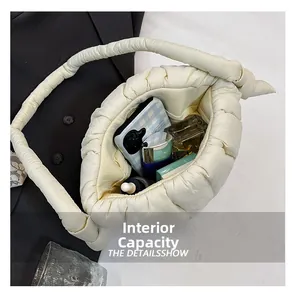 Detail view of the spacious interior capacity of this cream quilted puffer shoulder bag