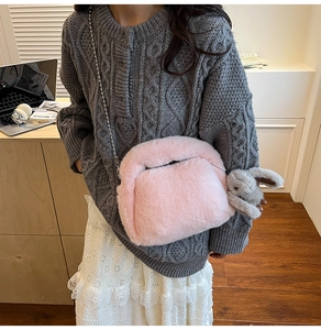 Détail du sac bandoulière en peluche rose avec chaîne argentée et pendentif lapin gris
