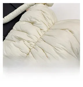 Macro detail of white pleated cloud bag showing quilted texture and premium stitching