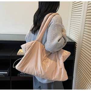 Détail d'un grand sac cabas matelassé rose lotus porté par un mannequin de dos