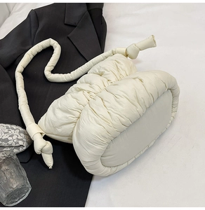 Detailed view of cream puffer cloud bag featuring quilted texture and knotted shoulder strap