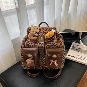 Leopard print backpack with brown leather trim and cute plush charms for women