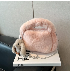 Détail d'un sac à main en peluche rose avec texture fausse fourrure et chaîne argentée