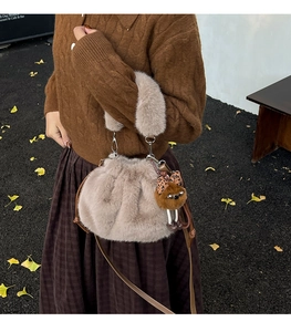 Detail view of plush faux fur shoulder bag with cute teddy pendant and leopard bow
