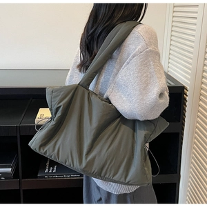 Détails d'un grand sac cabas matelassé vert foncé avec des cordons de serrage ajustables
