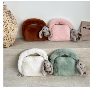 Detail view of four colorful plush handbags with cute bunny charms and metal chains