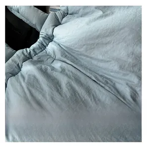Close-up of the light blue quilted fabric texture and soft pleats on a tote bag