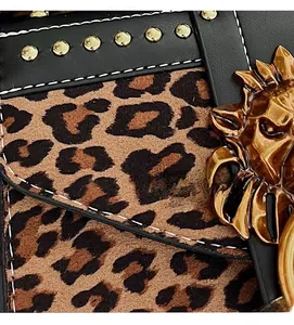 Close-up of leopard print suede texture with golden lion head emblem and metal rivets