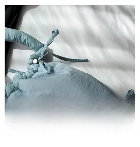 Detail of light blue bucket bag showing soft fabric texture and drawstring metal buckle