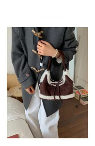 Detailed close-up of brown suede tote bag featuring cream faux shearling trim and bow
