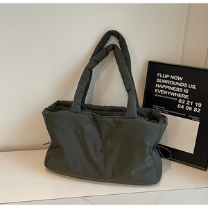 Detail of soft olive green quilted puffer tote with drawstring sides and thick handles