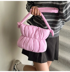 Detail of pink quilted cloud bag featuring soft padded texture and knot shoulder strap