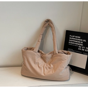 Détail du sac cabas matelassé en nylon beige avec de larges poignées rembourrées