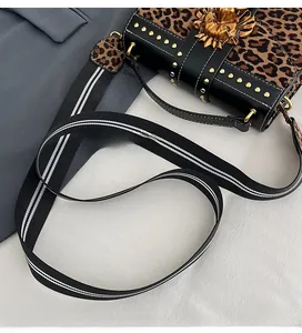 Close-up of leopard print handbag with golden lion head buckle and metal rivet details