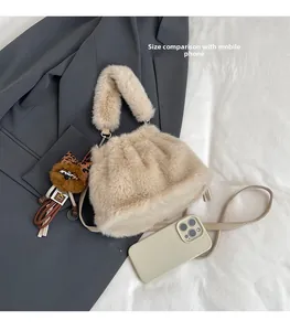 Detailed comparison of beige plush bucket bag size next to a smartphone