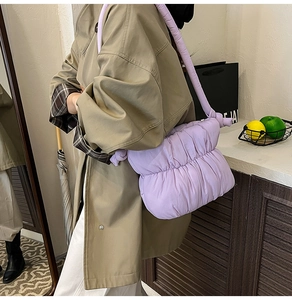 Detail of light purple pleated cloud bag with knotted strap on khaki coat