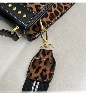 Detail of leopard print suede bag featuring golden hardware and black leather stitching