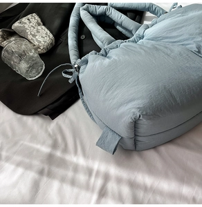 Light blue quilted bucket bag with padded texture shown in a lifestyle home setting