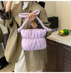 Macro detail of lavender quilted puffer bag with pleated fabric and knot handle