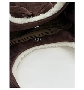 Detail view of the magnetic closure and white faux shearling lining on the brown tote