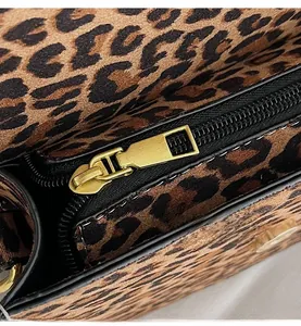 Detailed close-up of premium leopard print suede fabric and smooth gold metal zipper puller