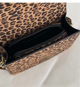 Detail view of leopard print faux suede bag featuring multiple interior compartments and gold zipper