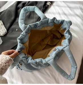 Detailed interior of quilted blue nylon tote showing large capacity and brown lining
