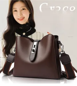 Détail du sac seau en cuir marron avec fermoir argenté et large bandoulière amovible