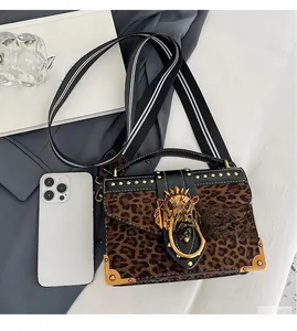 Detail of leopard print suede crossbody bag with gold lion head clasp and metal corners