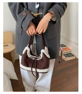Brown suede tote bag with white faux shearling trim and bow detail shown on shoulder