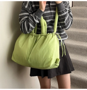 Macro shot of bright green puffy nylon tote bag showing soft texture and stitching detail
