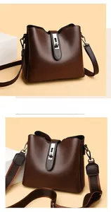 Détail du sac seau marron foncé avec deux bandoulières amovibles et texture grainée