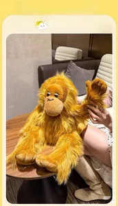 Close-up of the long-haired orangutan plush doll sitting on a wooden table surface