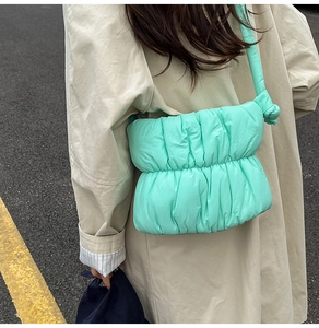 Detailed view of mint green pleated puffy shoulder bag with soft quilted texture
