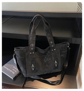 Detail of dark grey tote bag featuring vintage rivets, silver metal rings and buckles