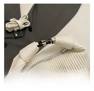 Détail de la texture en cuir plissé blanc et des boucles en métal argenté du sac à main