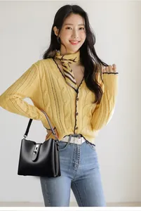 Détail du sac à main en cuir noir grainé avec boucle argentée et bandoulière réglable