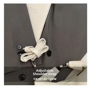 Gros plan détaillé d'un sac à main blanc en cuir gaufré avec bandoulière réglable